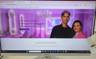 Homepage eines Online-Shops für Kosmetikerinnen, mit einem Paar im Vordergrund und Texten über Beauty-Geräte und Schulungen.